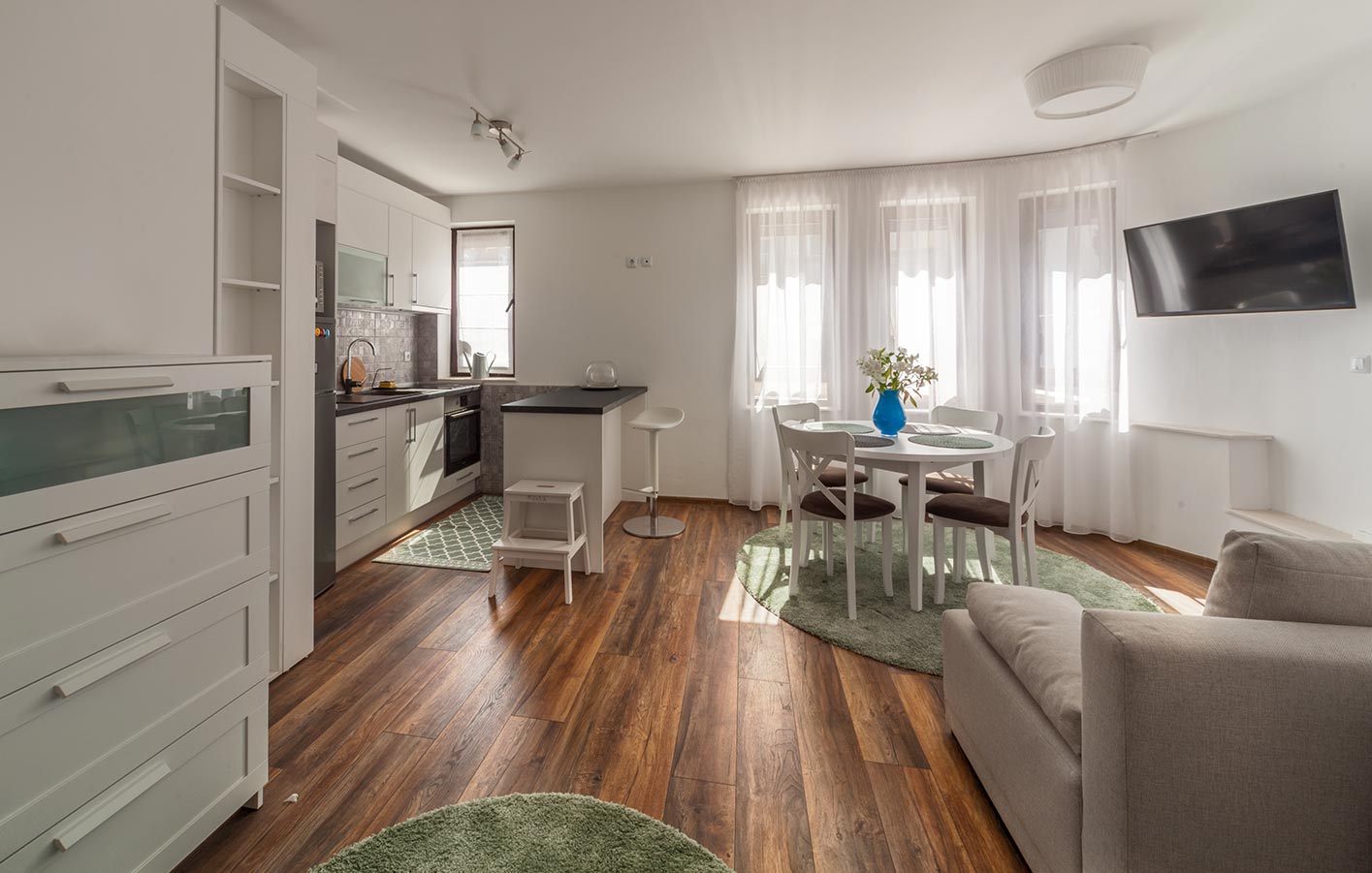 moderne weiße Küche mit dunklem Parkettboden